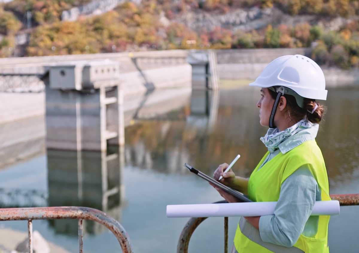 Maintenance female engineer working in hydroelectric power station. Renewable energy systems.
